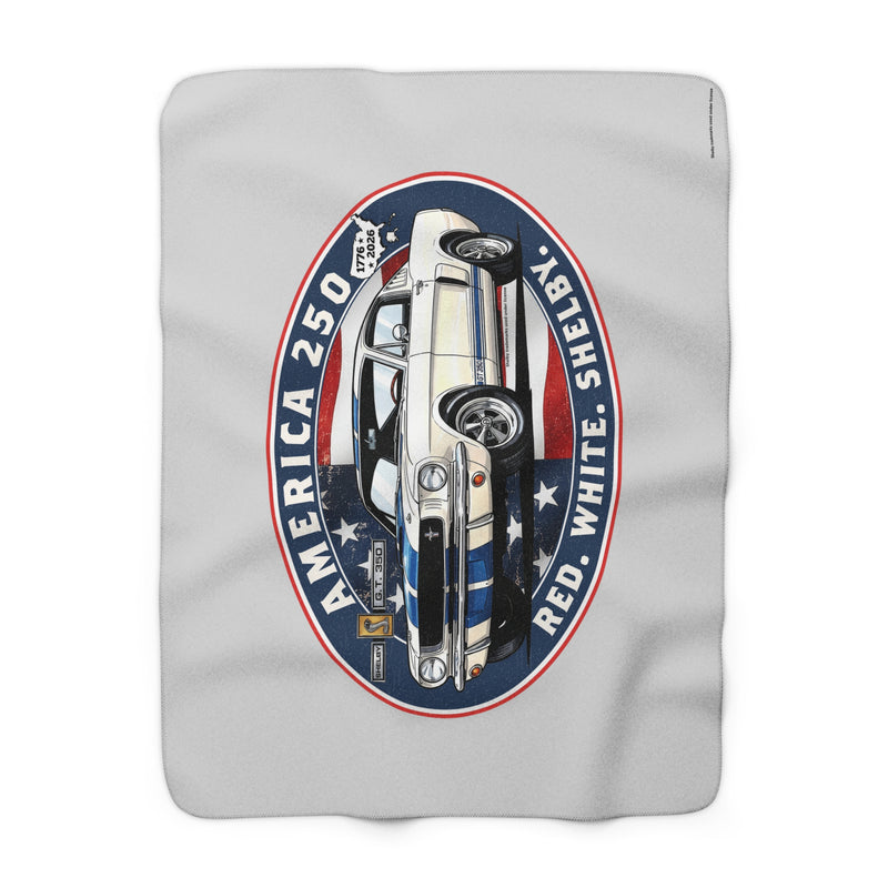 A light gray fleece blanket featuring a large graphic print of a classic car inside a circular emblem with the text 'AMERICA 250', 'SHERIFF', and 'RED, WHITE, AND BLUE'.