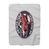 A light gray blanket featuring a large vintage-style oval graphic of a red, white, and blue classic car with the text 'AMERICA 250', 'SHELBY', and 'RED WHITE'.